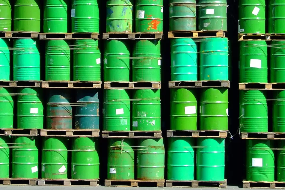 pallets of green oil barrels stacked